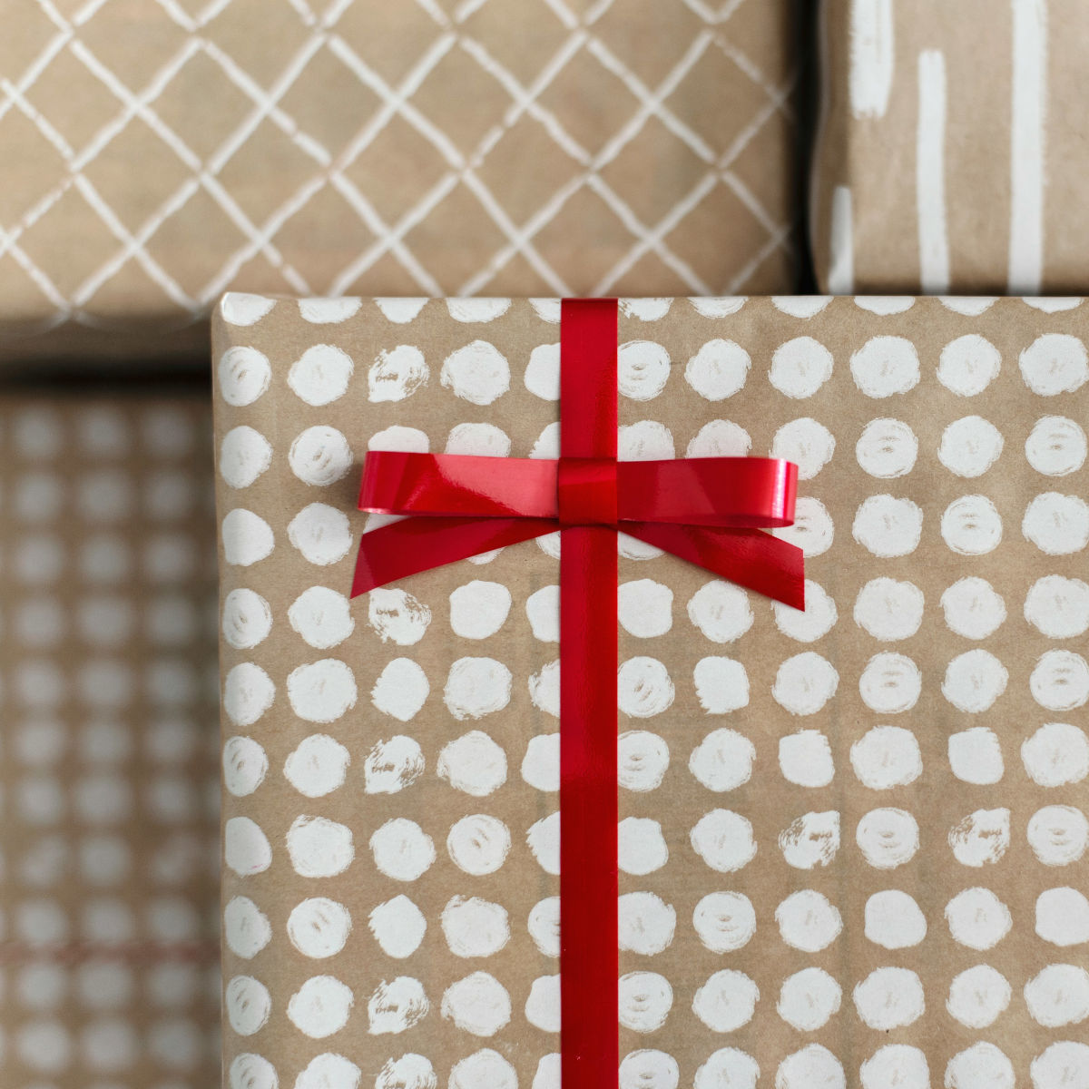 Paket inslagna i ljusa färger med enkla mönster som är inlindade i rött snöre