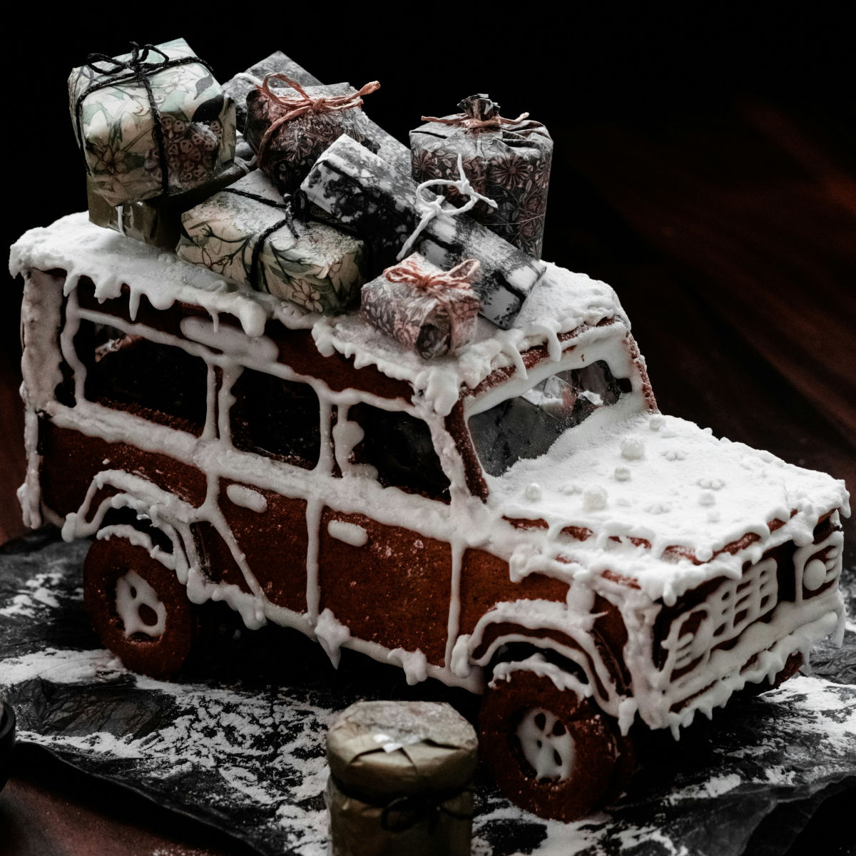 En pepparkaksbil med paket på taket, täckt i vit glasyr