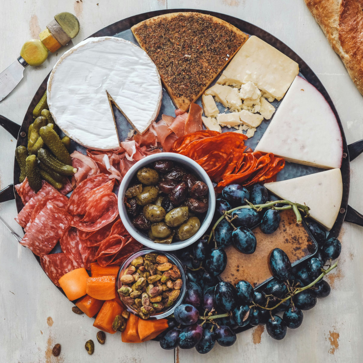 En ost och charkbricka med oliver, nötter och vindruvor