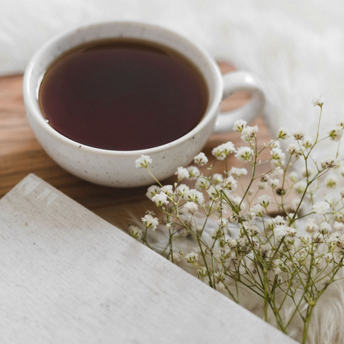 En kopp te på ett bord med blommor